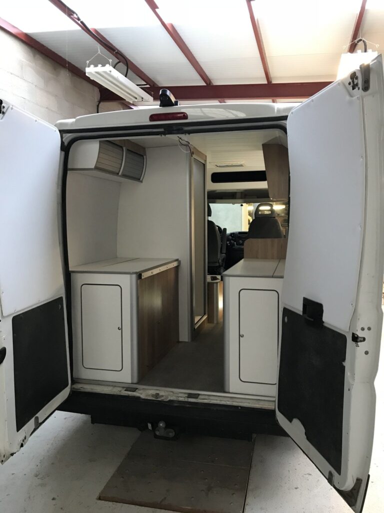 Detalle de la puerta trasera abierta con espacio de almacenamiento en la Camper Peugeot Boxer L2H2 4+2 de Baovan Camper.
