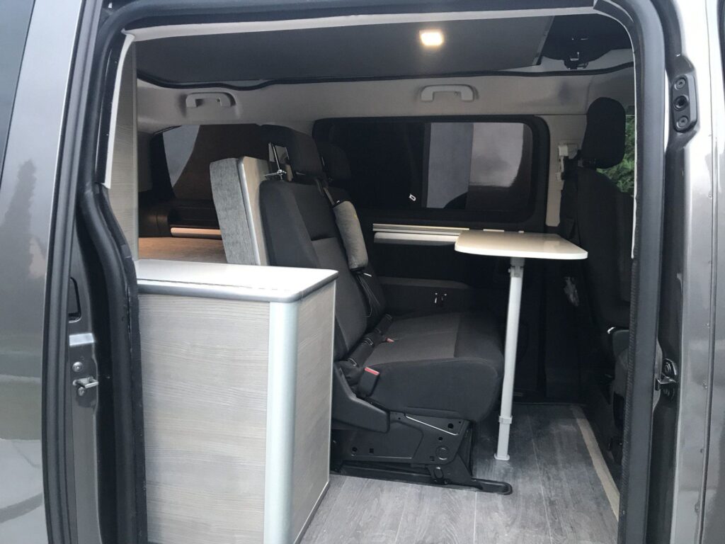 Detalle de la zona de descanso: mesa extensible y bancada en la Peugeot Traveller