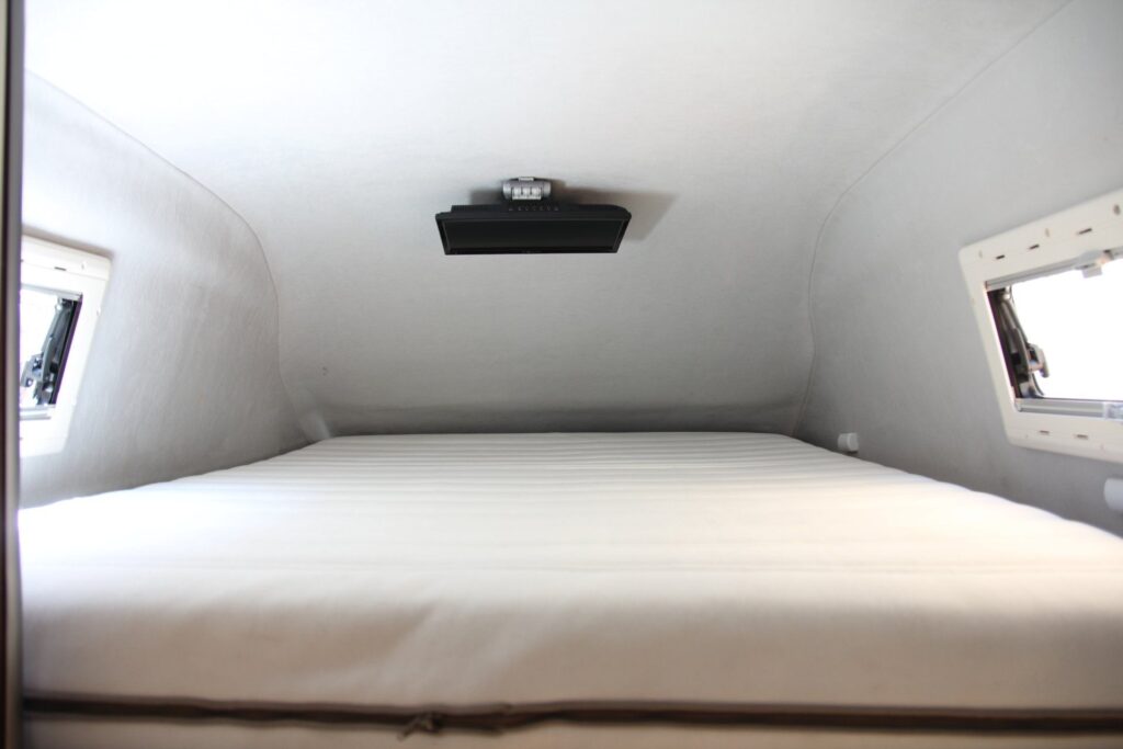 Detalles de la cama de dormir en el piso superior en la furgoneta VW Crafter por Baovan Camper.