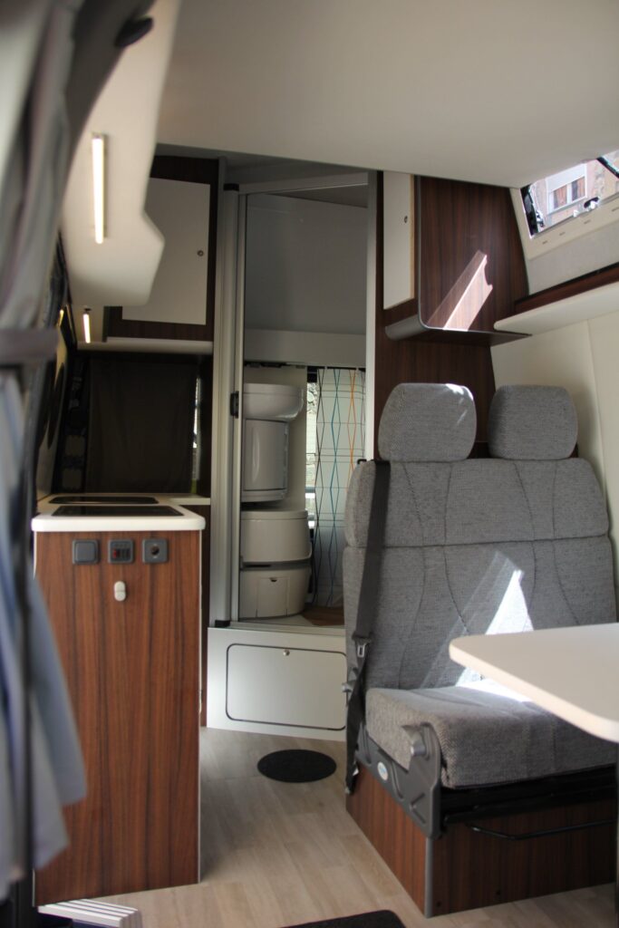 Detalle del área de esparcimiento con mesa y cocina en la furgoneta VW Crafter por Baovan Camper.