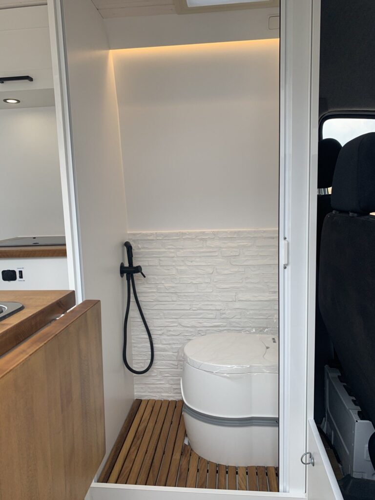 Detalle del baño completo con ducha de mano e inodoro en la Camper Mercedes Sprinter L3H2 4+4. Camperizado por BaovanCamper.