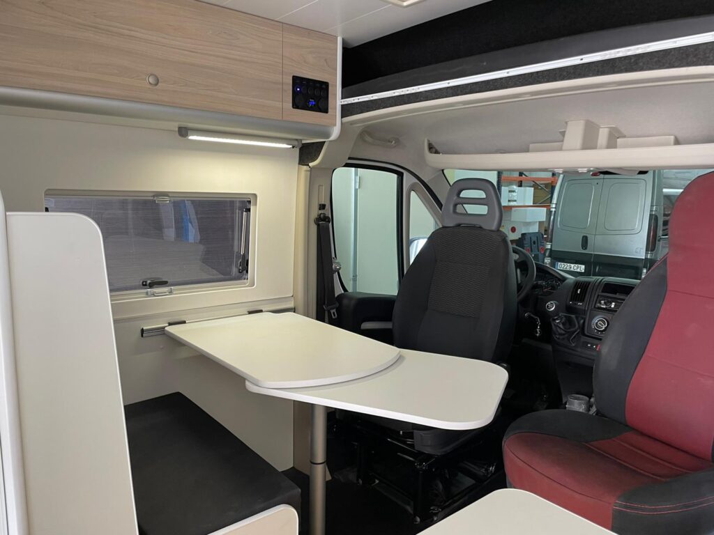 Detalle de los asientos delanteros: giratorios 180 grados, mesa abierta, Camperizado por Baovan Camper