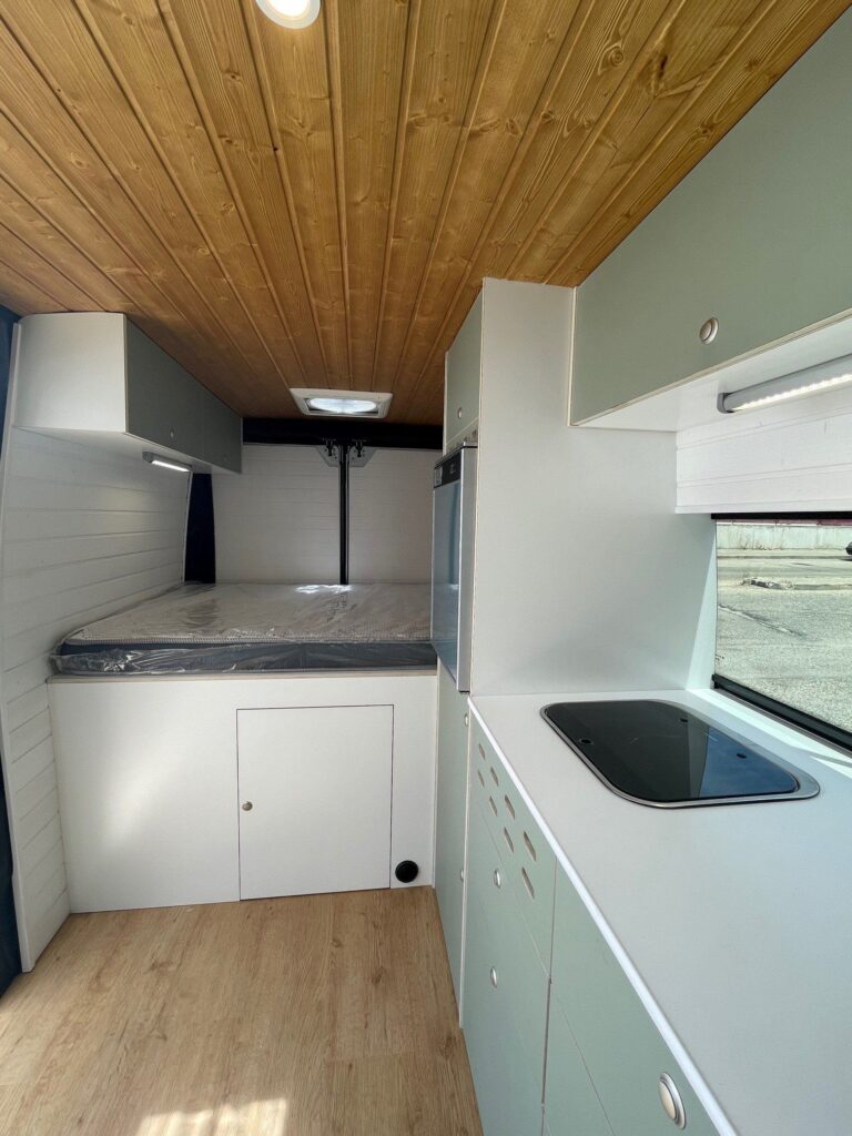Vista interna de los armarios, la cocina y la cama en la Camper Citroen Jumper 3+2.