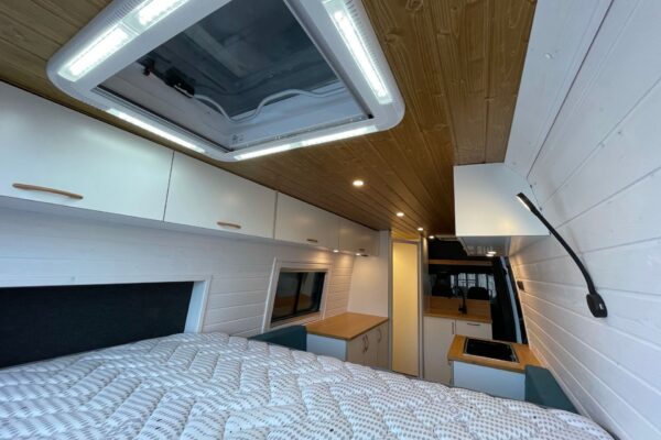 Vista desde la cama hacia delante en la Mercedes Sprinter L4H2 Camper para 3 con Garaje, mostrando claraboya.