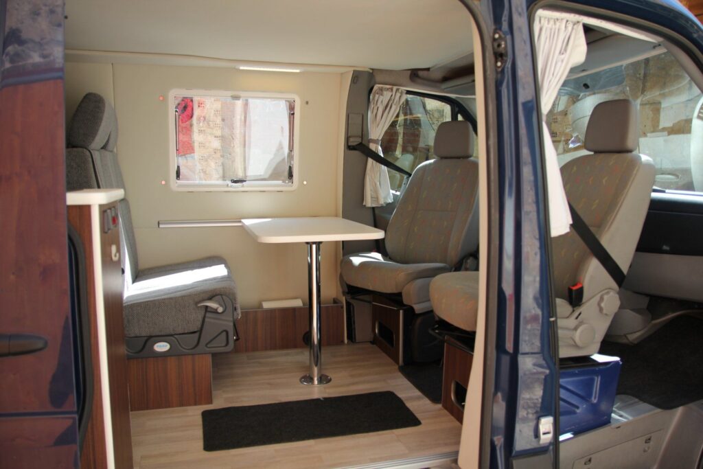 Detalle de la puerta lateral abierta revelando el área de esparcimiento en la furgoneta VW Crafter por Baovan Camper.