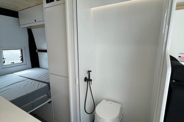 Baño completo blanco con ducha de mano en la Citroën Jumper L4H3 4+4, convertida por Baovan Camper.