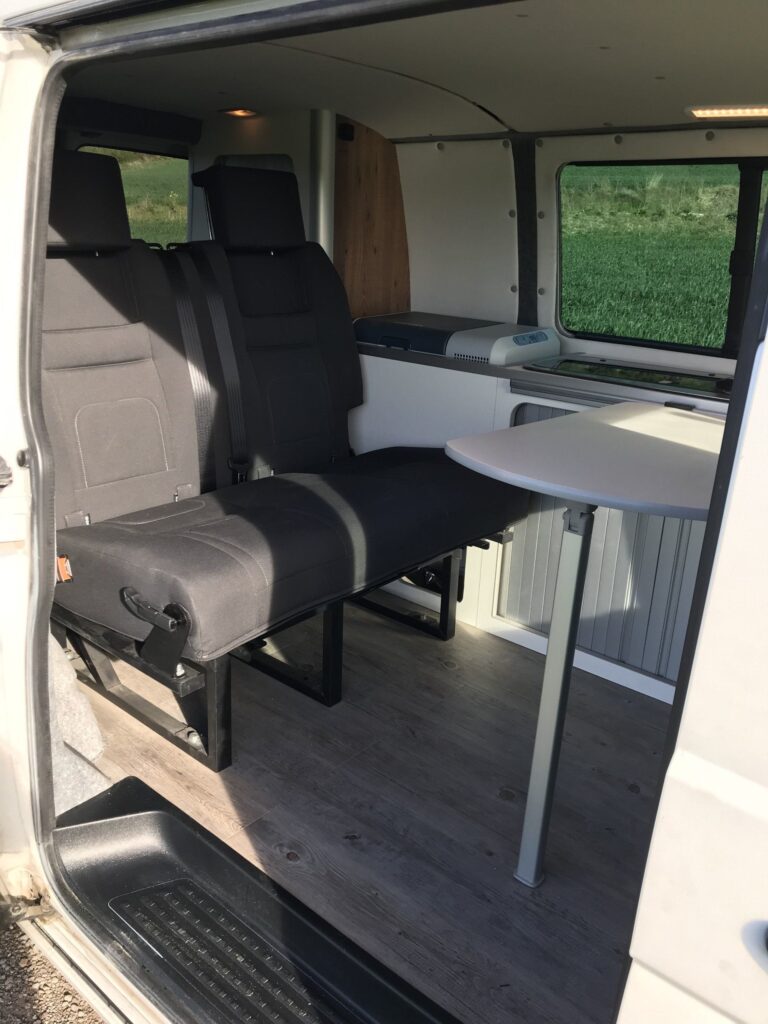 Detalle de la zona de descanso: mesa extendida y dos sillas en la Volkswagen Transporter T5