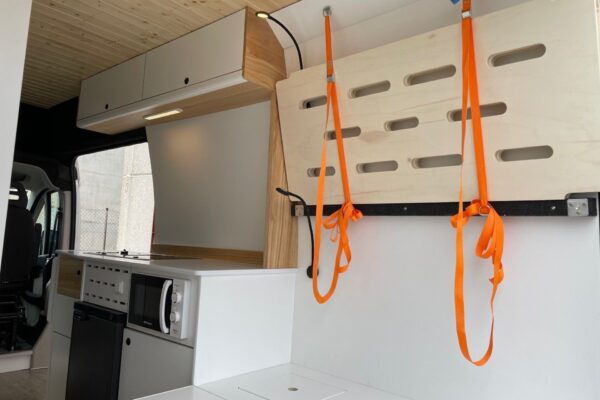 Detalle de la estructura plegable de una segunda cama en la Citroën Jumper L4H3 4+4, convertida por Baovan Camper, plegada en la pared.