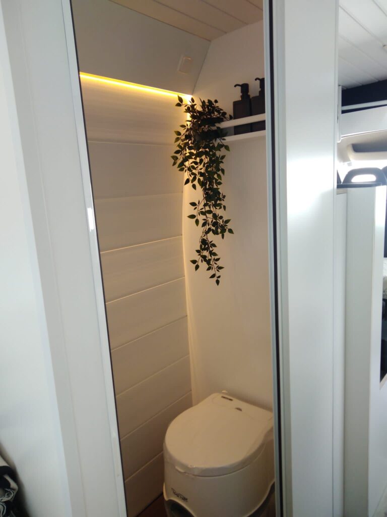 Detalle del baño completo con iluminación y acabado blanco elegante en la Peugeot Boxer L3H2 4+2 CORIAN, Camperización por Baovan Camper.