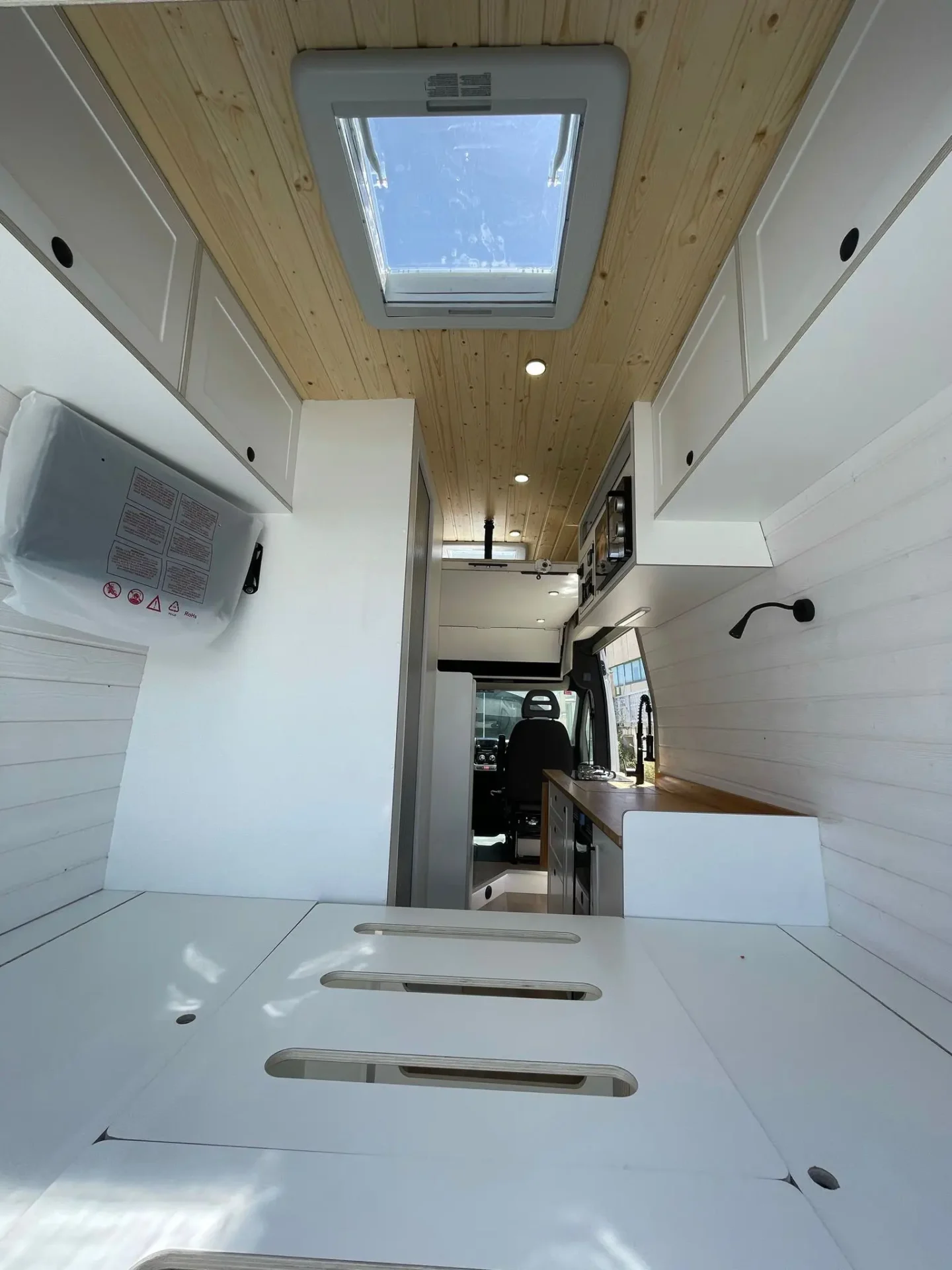Detalle del techo de la furgoneta camper Ducato L4H3 con ventanas de techo, iluminación LED y acabados de madera, ofreciendo una sensación aireada y abierta.