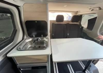 Renault Trafic Camper con espacio de descanso abierto: fregadero, mesa y espacio para sentarse.