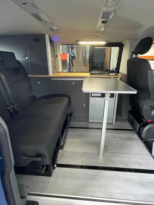 VW T6 Camper con mesa plegable abierta, comodidad y espacio para las comidas.
