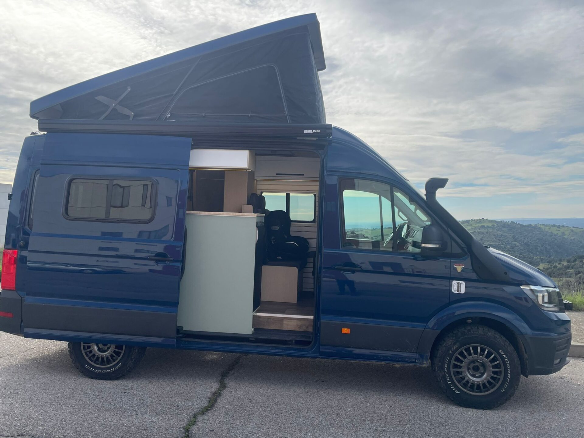 Exterior de un camper Baovan con techo elevable expandido, mostrando capacidad y diseño innovador para aventuras al aire libre.