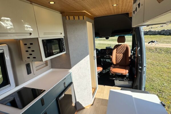 Interior camper con pasillo y zona de estar iluminada