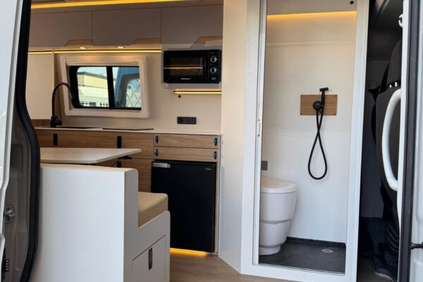 Interior camper con zona de cocina y mueble blanco