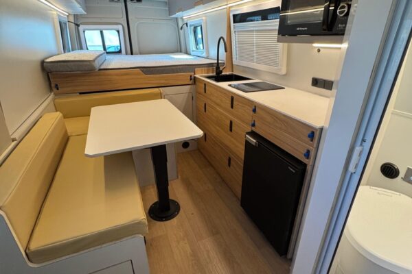 Interior camper con zona de estar y ventana lateral
