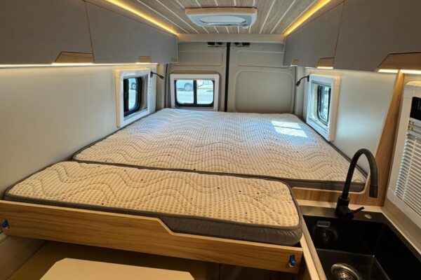 Interior furgoneta camper con cama y almacenaje lateral