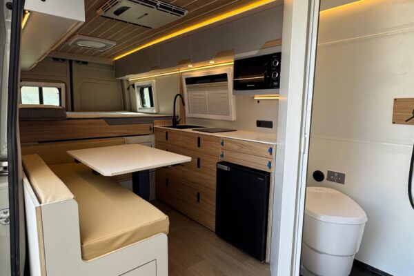 Zona trasera furgoneta camper con cama y ventana